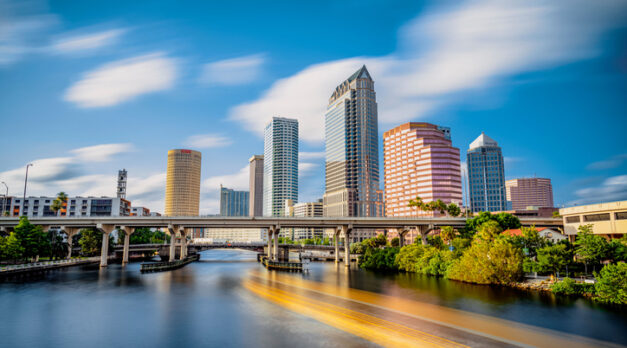 The skyline of downtown Tampa on the Hillsborough river under a blue sky